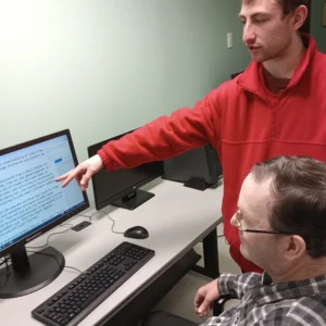 Cushing adult and teacher helping at the computer at LOU Program