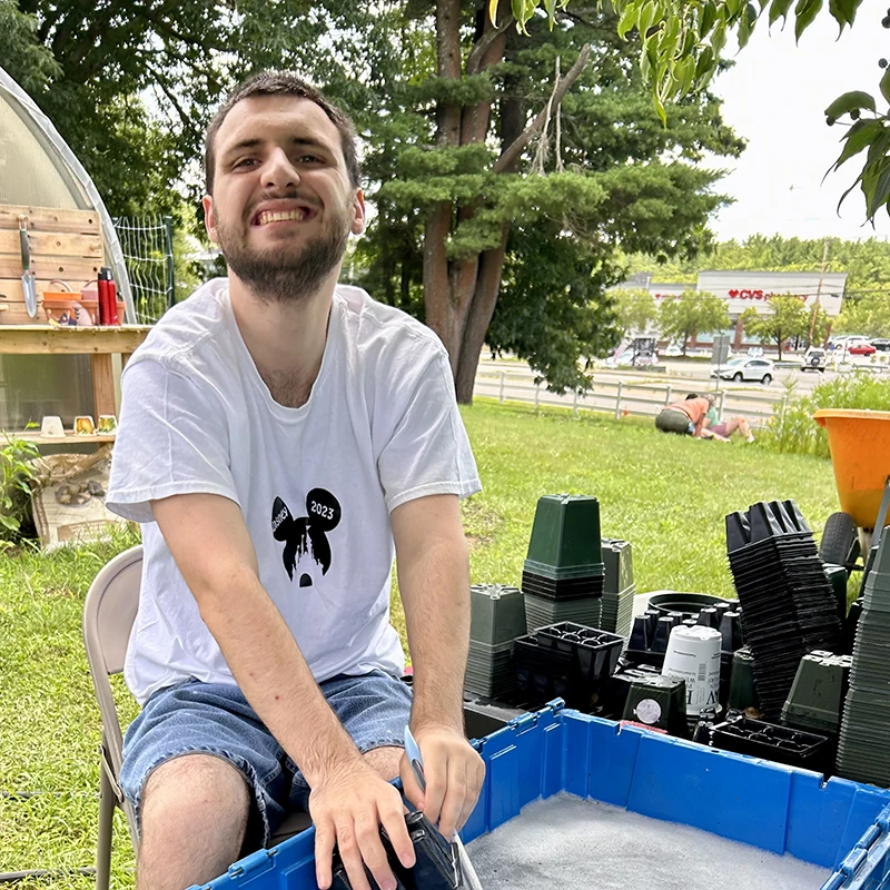 Student washing pots at the Cushing greenhouse