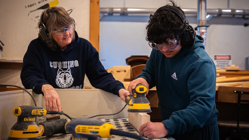 Teacher helping an individual at the Cushing Woodshop